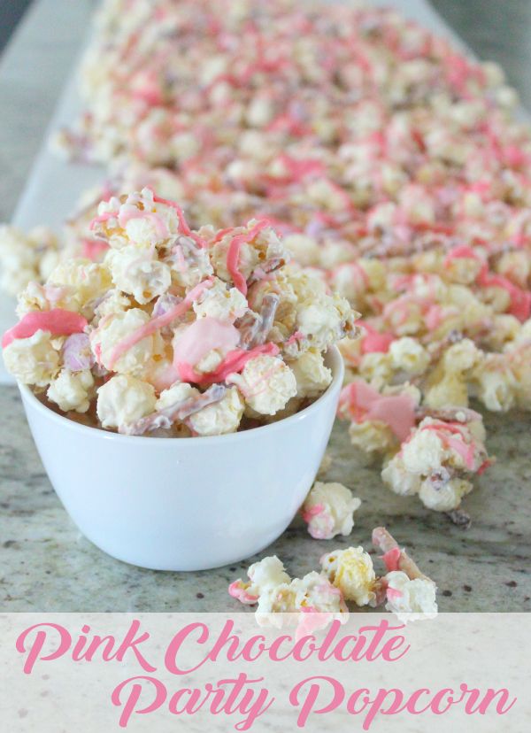 pink and white party popcorn in a bowl