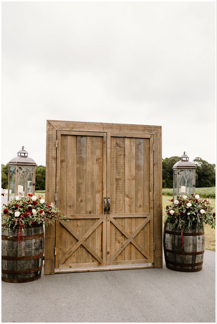 two large wooden barrels with flowers in them