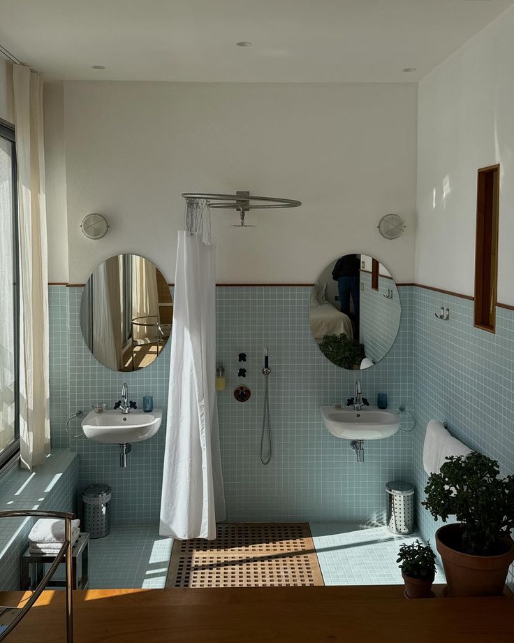 a bathroom with two sinks, a mirror and a shower head mounted to the wall