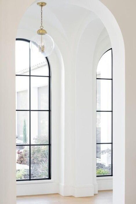 an empty room with arched windows and white walls is pictured in this image from the inside