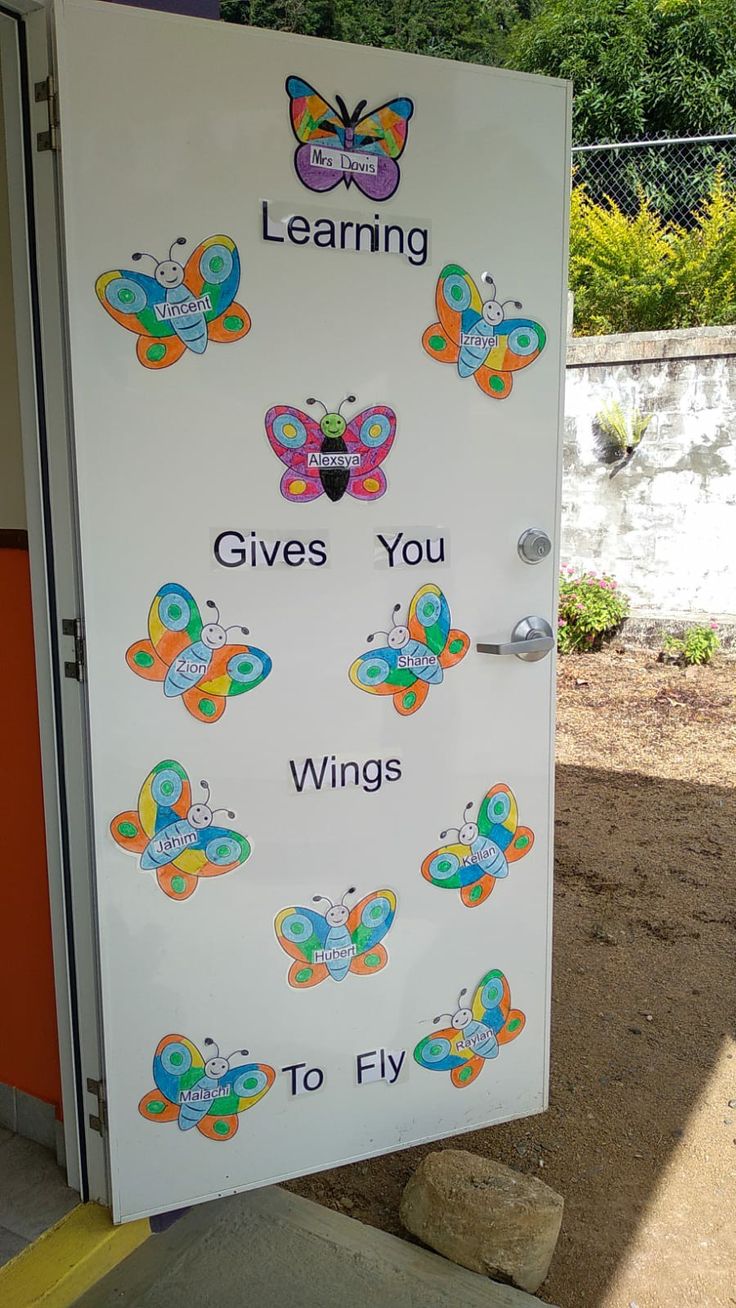 a white door with colorful butterflies on it and the words learning gives you wings to fly