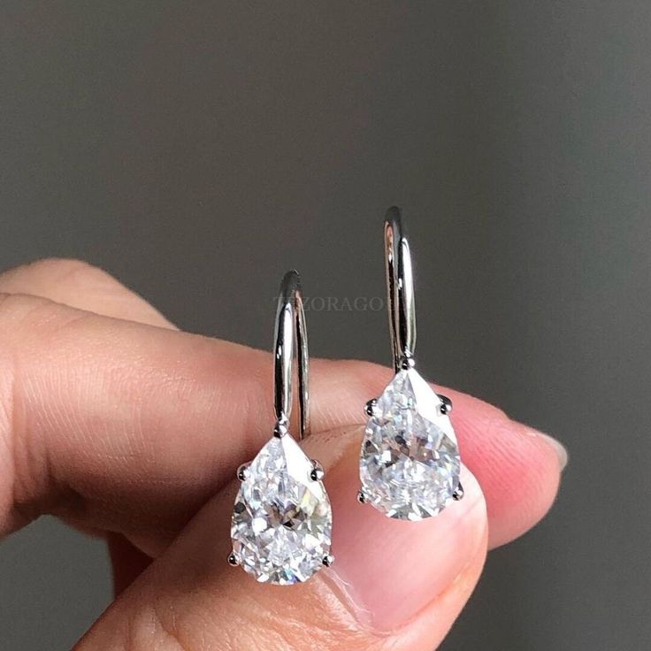 Classy Pear Cut Moissanite Drop Earrings, 14K Gold Teardrop Solitaire Earrings, Diamond Dangle Earring, Bridesmaid Earrings, Gift For Her ✥ Description of Earring: ● Moissanite Details: → Stone Shape: 𝐏𝐞𝐚𝐫 𝐂𝐮𝐭 → Stone Carat Weight : 𝟐.𝟎𝟎𝐂𝐓𝐖 (𝟐 𝐩𝐜𝐬 ) → Stone Measurement : 𝟕.𝟕𝐱𝟓.𝟕 𝐦𝐦 → Stone Color: Colorless → Stone Clarity: VVS → Stone Luster: Excellent → Stone Make: High Quality ● Metal Details: → Metal type: Gold → Metal Purity: 14 KT → Metal Tone: White → Metal Stamp: Yes ● Closure: Wire Wrapped ❁❁𝐂𝐮𝐬𝐭𝐨𝐦𝐢𝐳𝐚𝐭𝐢𝐨𝐧 𝐃𝐞𝐭𝐚𝐢𝐥𝐬❁❁ : ↣ Customized Designer Jewelry. ↣ We Offer All cuts which you dream to make with moissanite, lab grown, lab created diamonds. ↣ Updating every step of your ordered jewelry. ↣ All listed jewelry in our stores is made to order. Customized Earrings, Pear Earrings, Engagement Earrings, Solitaire Earrings, Diamond Dangle Earrings, Moissanite Earrings, Beautiful Engagement Rings, White Gold Earrings, Custom Earrings