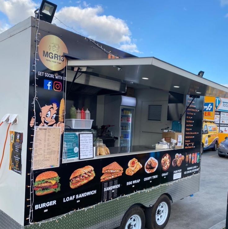 the food truck is parked on the side of the road in front of other vehicles