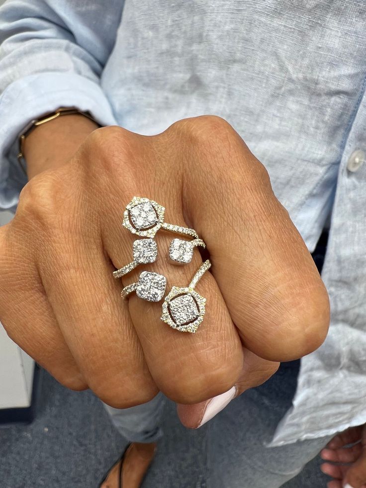 a person's hand holding three rings with diamonds on each one and the other