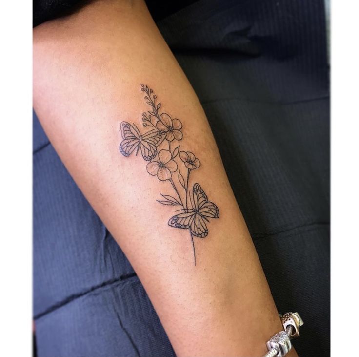 a woman with a tattoo on her arm has a butterfly and flower design on it