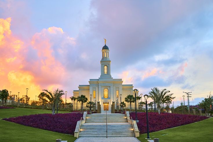 a large white building with a steeple at sunset