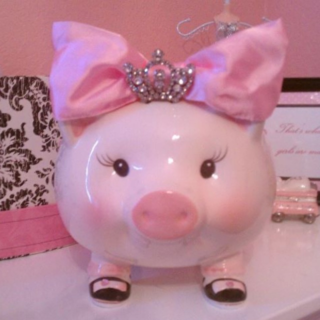 a piggy bank with a tiara on it's head sitting on a table