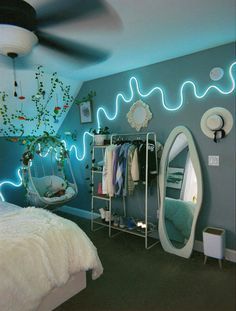 a bed room with a neatly made bed next to a hanging chair and mirror on the wall