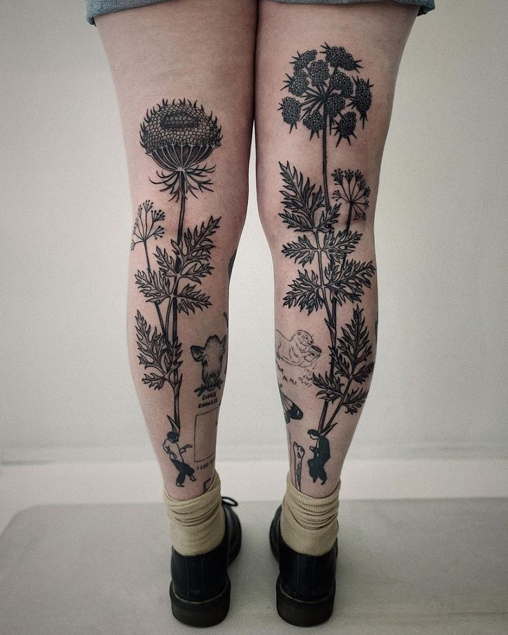 a woman's legs with tattoos and flowers on them