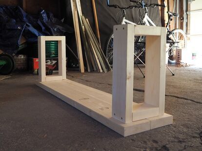 two wooden frames sitting next to each other in a room with bikes parked behind them