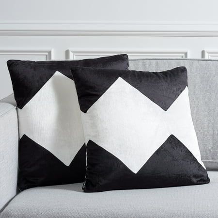 two black and white pillows sitting on top of a couch