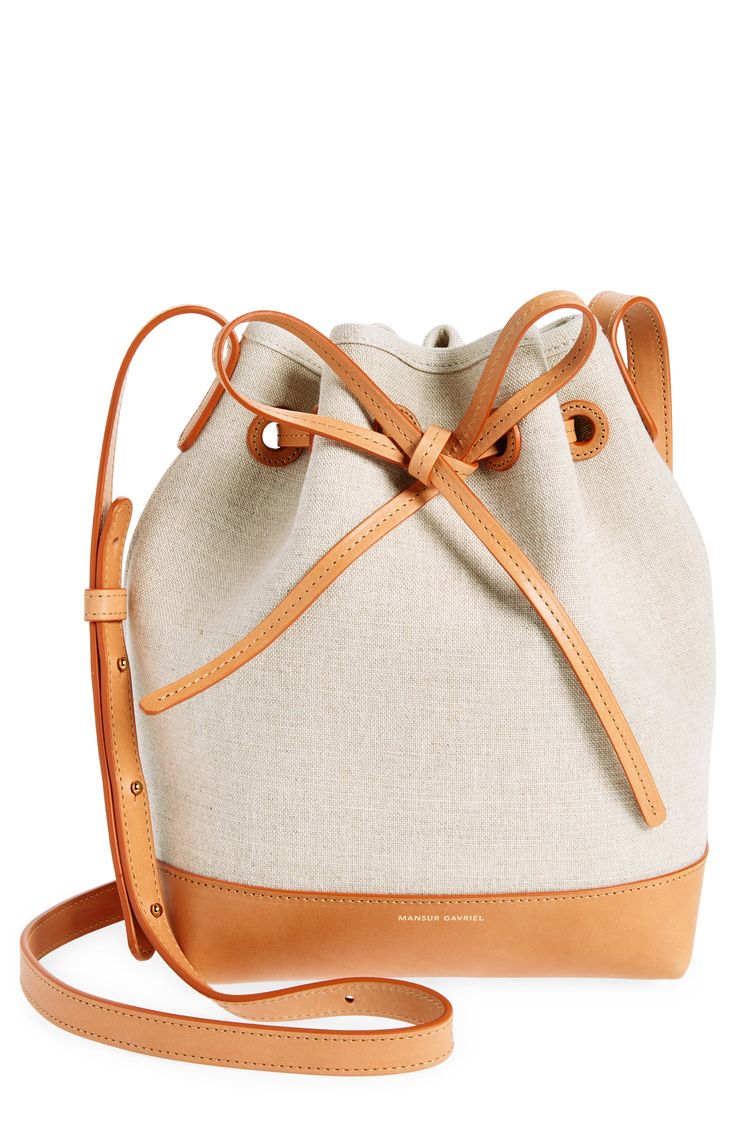 Cool Italian canvas and luxe leather shape a petite bucket bag with sturdy structure and a drawstring-cinched top. Drawstring closure Adjustable crossbody strap Structured silhouette with flat base for stability Textile with leather trim Made in Italy Designer Handbags Cinched Top, Crossbody Bags For Travel, Travel Bags For Women, Mansur Gavriel, Leather Bucket Bag, Leather Bucket, Handbag Straps, Mini Canvas, Canvas Leather