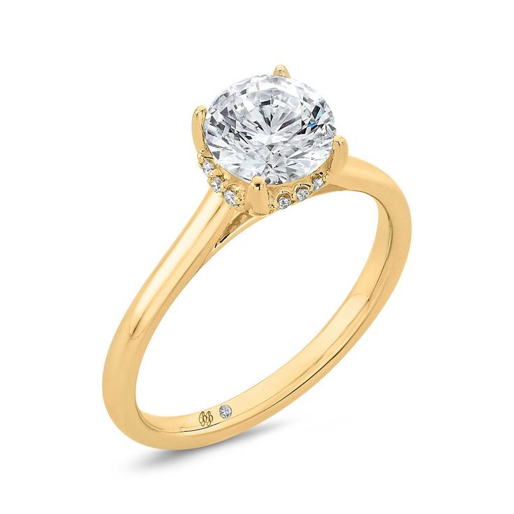 a yellow gold engagement ring with a round diamond