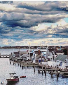 boats are docked in the water next to houses and piers on a cloudy day