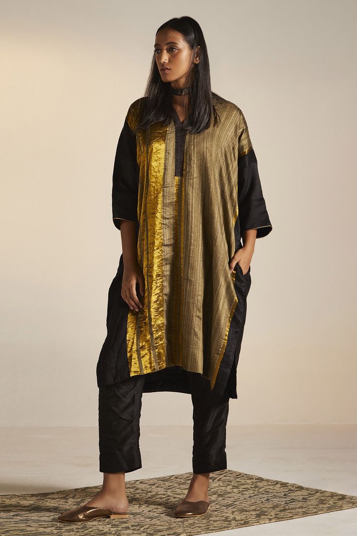 Black, gold colorblock kaftan tunic with stripe pattern. Paired with pant.
Component: 2
Type Of Work: Stripe
Neckline: V neck
Sleeve Type: Three quarter
Fabric: Handwoven Pure Silk, Cotton Silk
Color: Black,Gold
Other Details: 
Approximate Product Weight (in kg): 1
Side pockets
Note:
Dupatta worn by the model is not for sale
Since all our products are sustainable and touched by human hands for weaving, block printing and embroidery; there might be a slight imperfections that make them unique and Kaftan Tunic, Black Kaftan, Kaftan Designs, Silk Kaftan, Human Hands, Silk Tunic, Blazer Set, Boho Chic Outfits, Indian Fashion Dresses