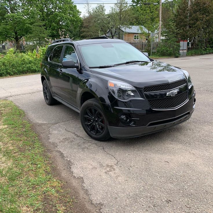 the chevrolet suv is parked on the side of the road