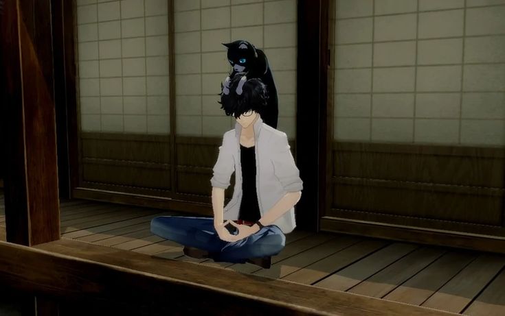 a person sitting on the floor with a black cat mask on their head, in an empty room