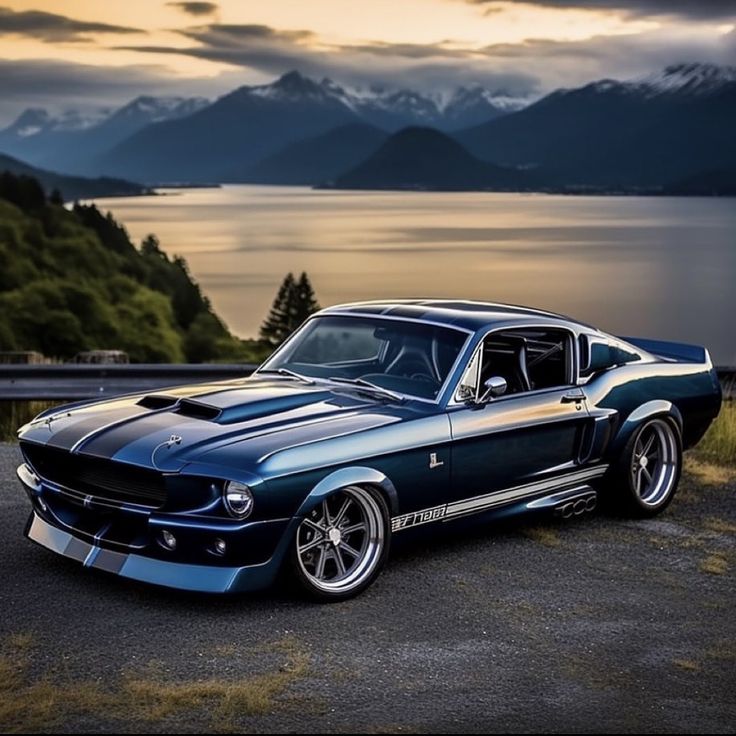 a car parked on the side of a road next to a body of water with mountains in the background