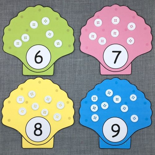 four different colored paper numbers on a gray surface with one number in the middle and two numbered