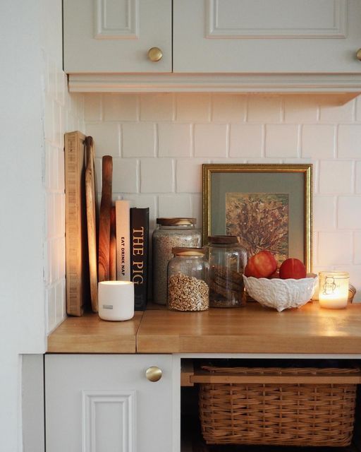 the kitchen counter is covered with books, candles and other items on it's shelf