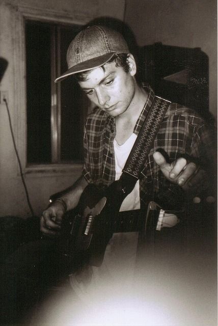 black and white photograph of man playing guitar