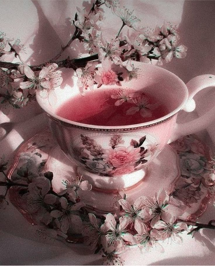 a pink tea cup and saucer with flowers on it