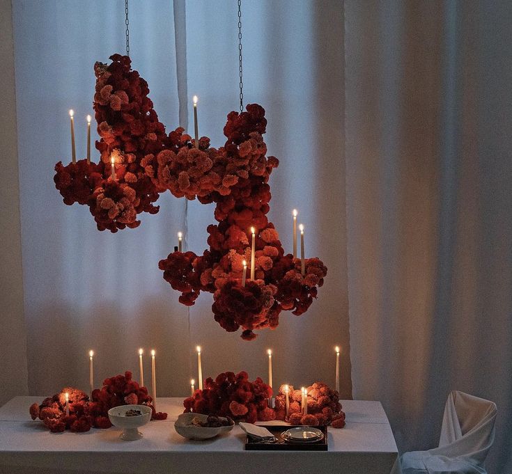 a table topped with candles and flowers on top of a white table cloth covered table