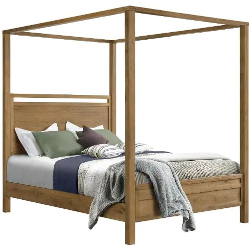 a bed with four posts and pillows on it