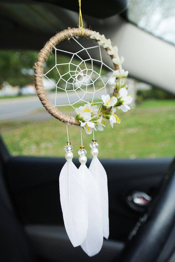 a car dashboard with a white dream catcher hanging from it's side