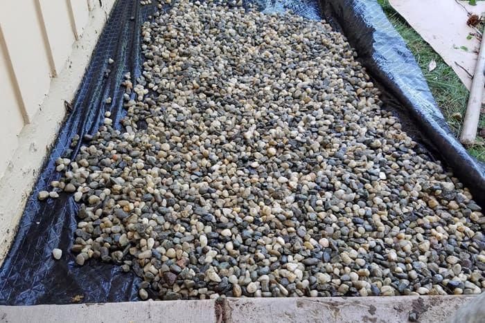 a pile of rocks sitting on top of a blue tarp next to a building