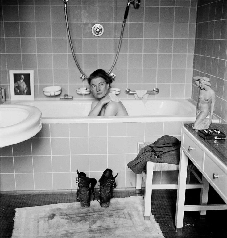 black and white photograph of a woman in a bathtub