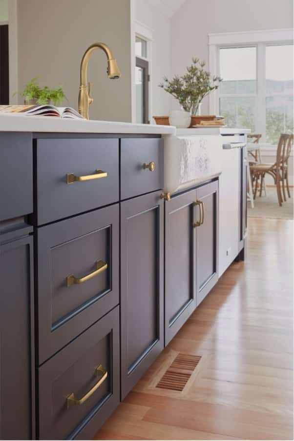 a kitchen with gray cabinets and white counter tops is seen in this image from the front