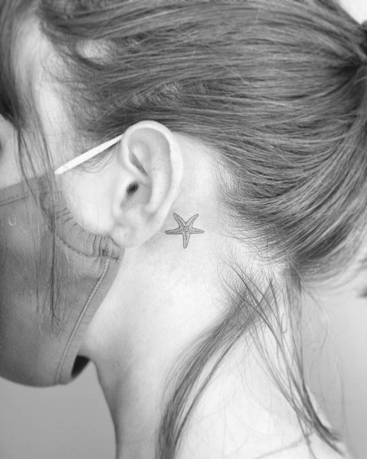 a woman with a small star tattoo on her left ear