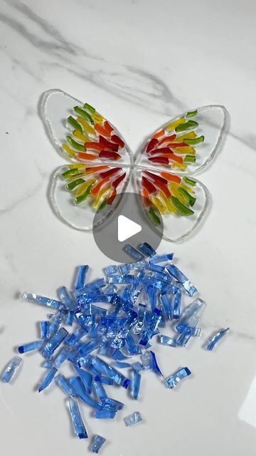 the butterfly is made out of plastic and has many small pieces of blue, yellow, red