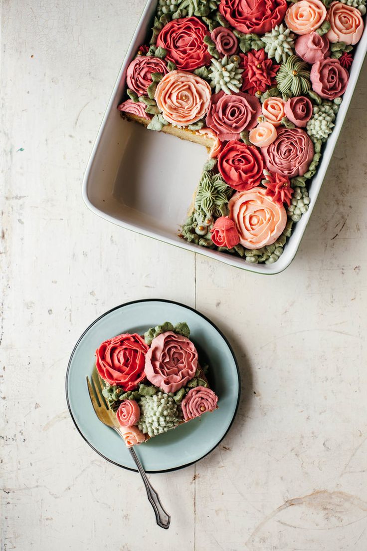 there is a cake with flowers on it and a fork next to the cake plate