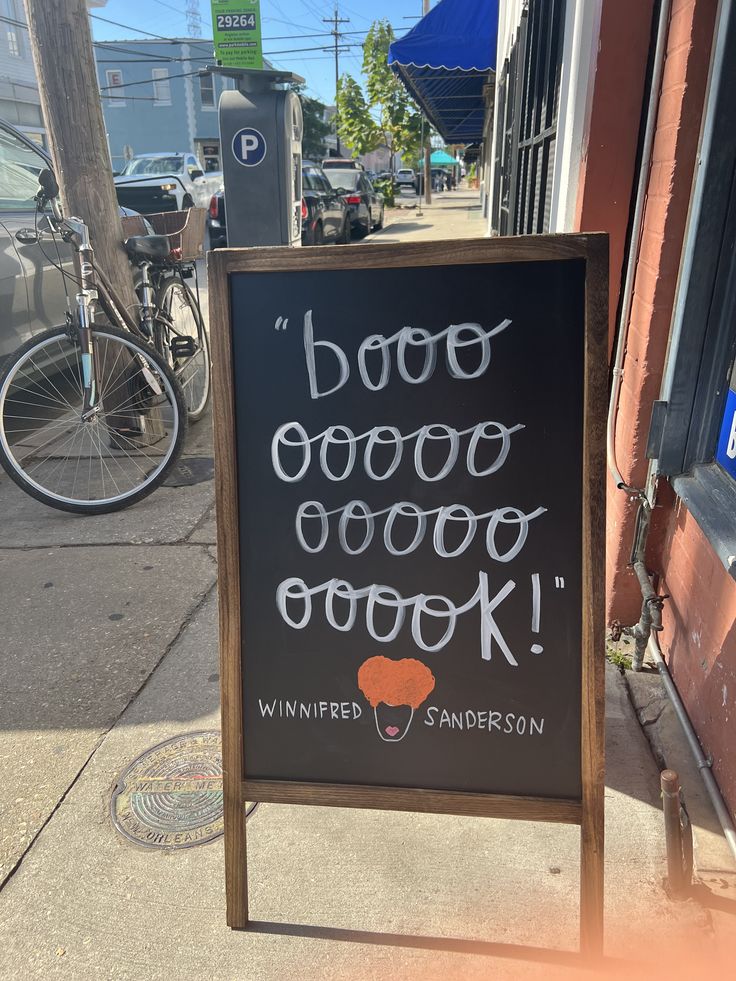 a sign on the sidewalk that says boooo good food cook's written in cursive writing