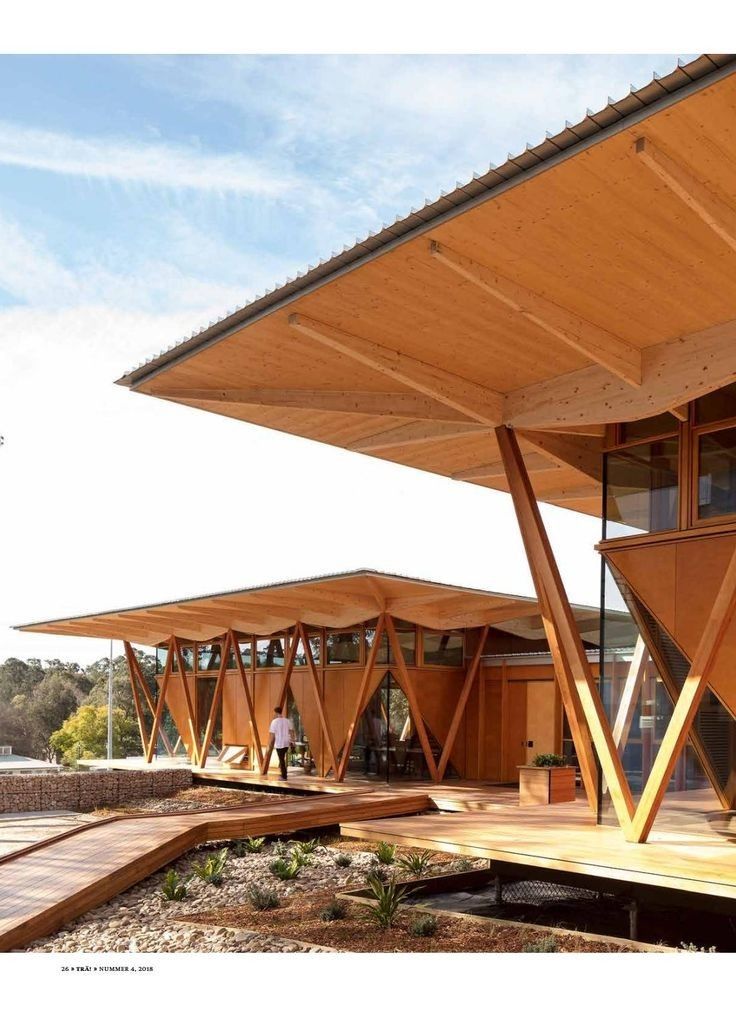 a wooden structure with many windows on the side and people walking around it in front