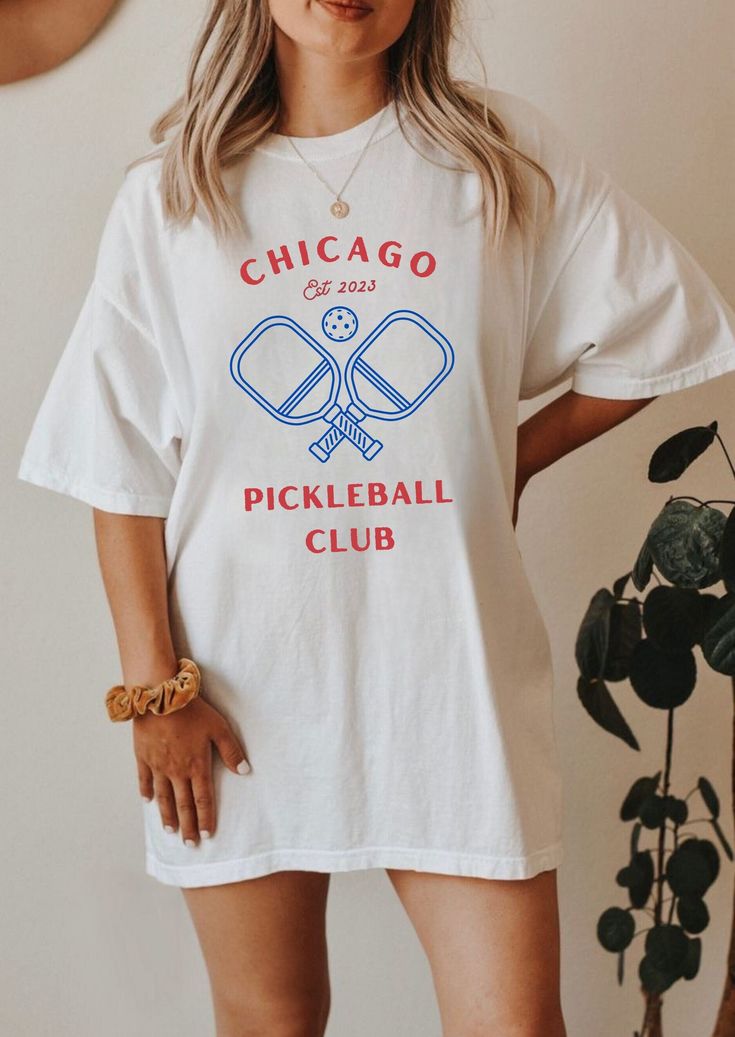 Get your game on with our Chicago Pickle Ball t-shirt! Designed for comfort and style, this soft tee features a captivating blue and red logo that pays homage to the windy city's love for pickleball. Stay trendy and show off your passion for the sport with this must-have shirt! This tee is 100% cotton for solid colors. Heather colors and sports grey include polyester. The shoulders have twill tape for improved durability. There are no side seams. The collar is made with ribbed knitting to prevent curling damage. **Please note, our policy is no returns/exchanges due to the nature of on-demand ordering, but please reach out with any order issues we will do our best to make it right! Pickle Ball Shirt, Pickleball Fashion, Pickleball Outfits For Women, Pickleball Sweatshirt, Pickleball Party, Pickleball Tshirt, Pickleball Shirts, Funny Pickleball Shirts, Pickleball Shirt