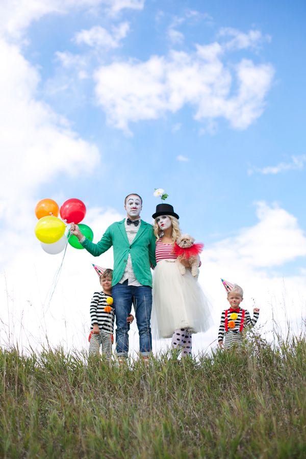 a man and two children with clown faces holding balloons