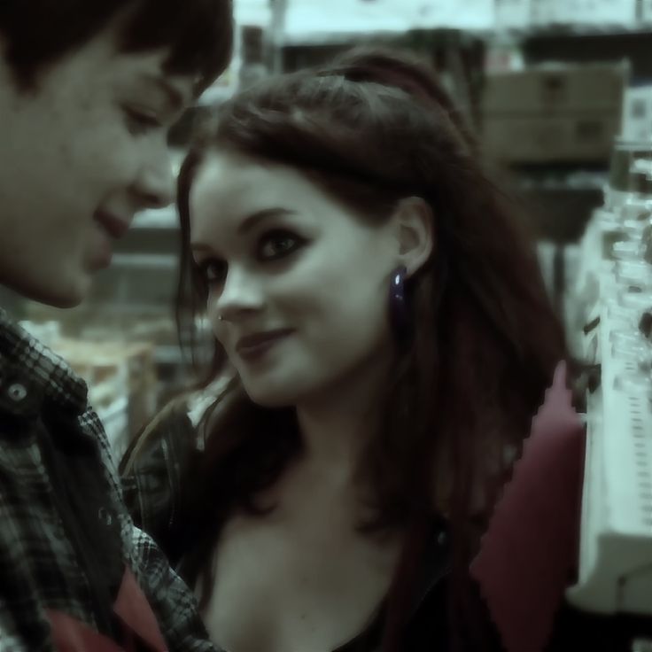 a man and woman standing next to each other in front of a store display case