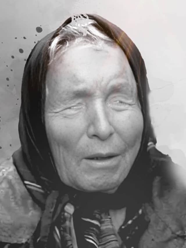 an old woman wearing a headscarf and looking at the camera with tears on her face