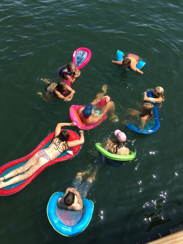 several people are floating on inflatable rafts in the water