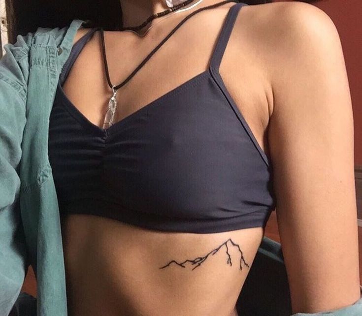 a woman with a mountain tattoo on her stomach