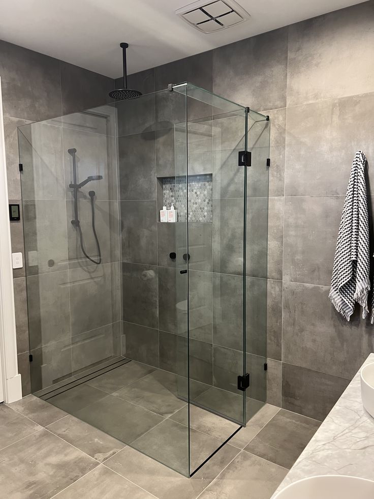 a walk in shower sitting next to a white sink