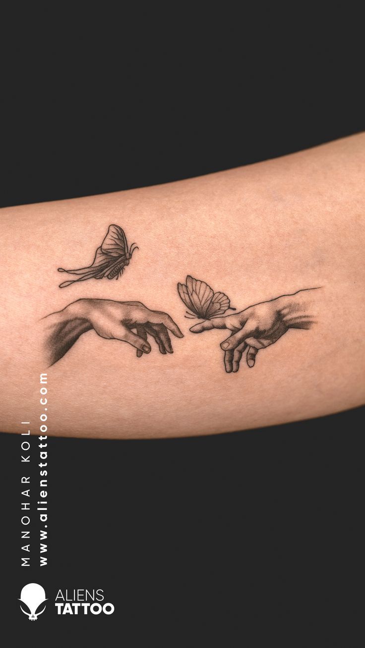 the hands of two people with butterflies on their arm