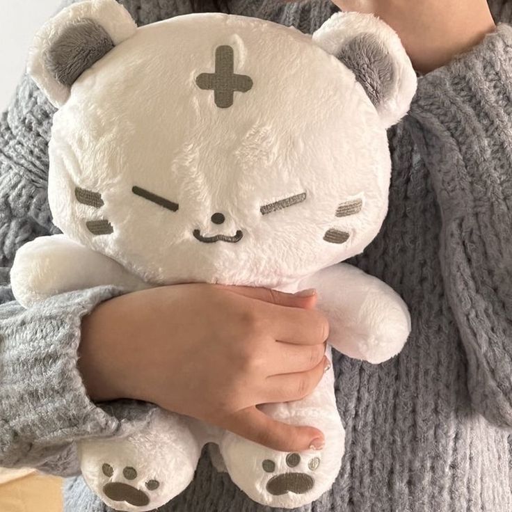 a person holding a white teddy bear in their arms