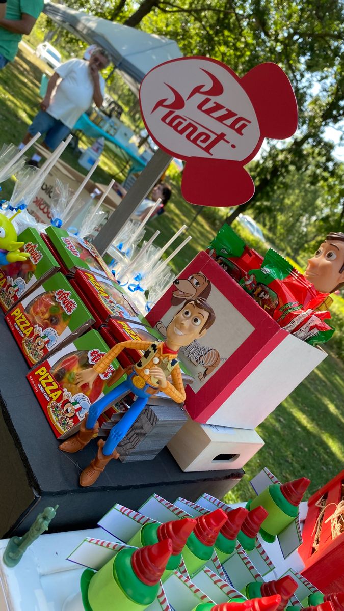 the table is set up with toy story books and toys for sale at an amusement park