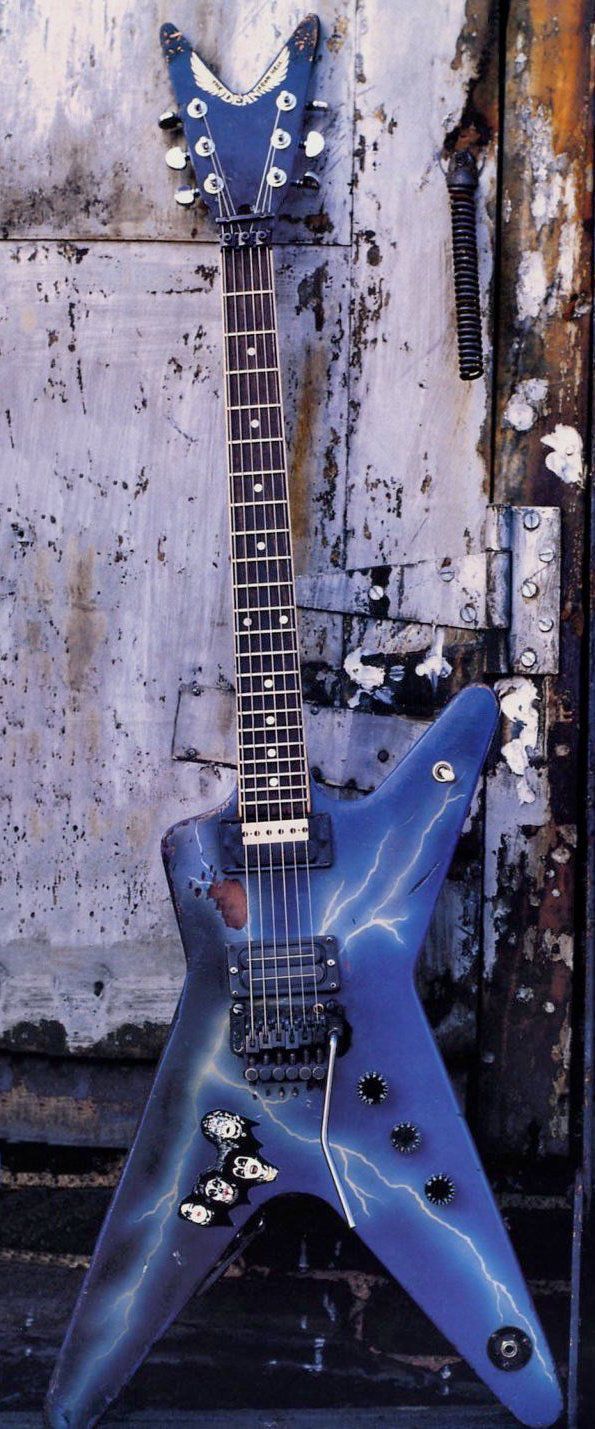 a blue guitar sitting on top of a wooden stand