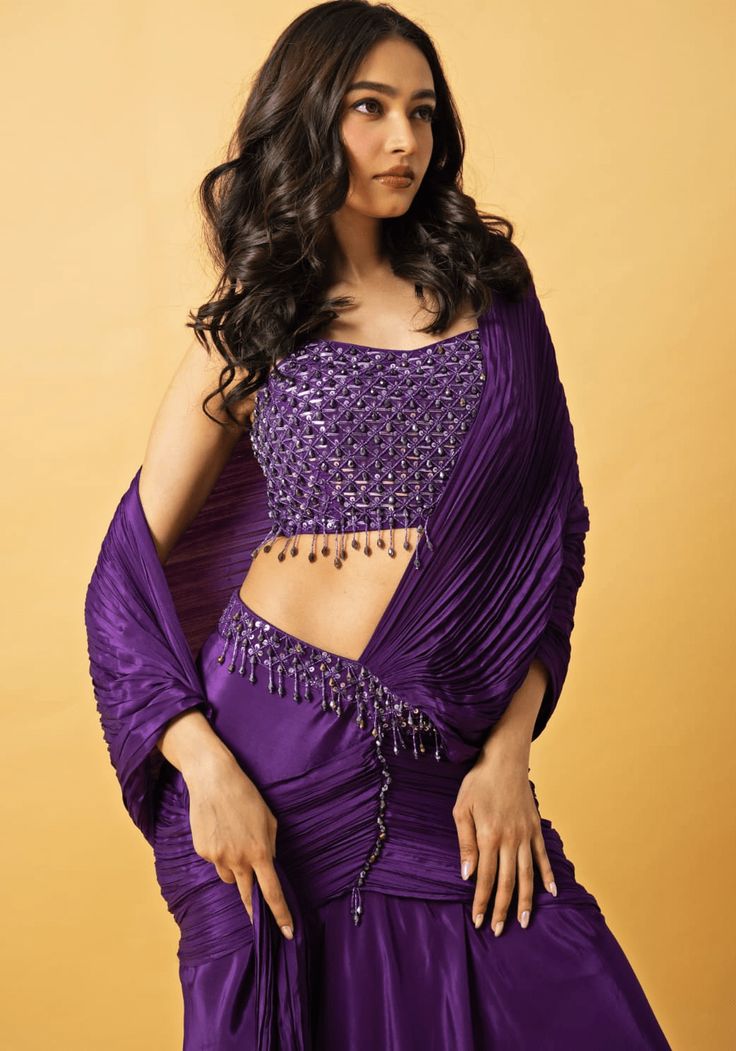 Featuring a stunning purple crepe pre-draped saree paired with a beautifully embellished sleeveless blouse in the same hue. The hand embroidery includes crystals and cutdana work adding exquisite detail to this elegant ensemble. Perfect for Wedding Reception or Sangeet This saree is pre stitched saree for your convenience. Composition : Saree and Blouse - Crepe Care: Dry Clean Only and Vacuum Storage This product can be customized for sleeves, length of blouse and neckline Delivery : 2-4 weeks a Blouse Hand Embroidery, Pre Draped Saree, Pre Stitched Saree, Baby Pink Saree, Pant Saree, Yellow Drapes, Cutdana Work, Mirror Work Saree, Stitched Saree