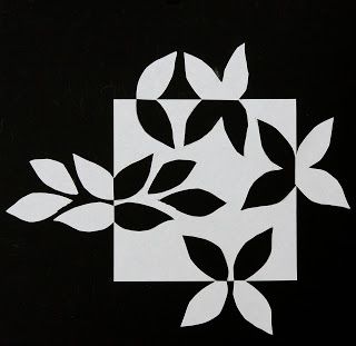 a black and white square with leaves on it's sides, in the center